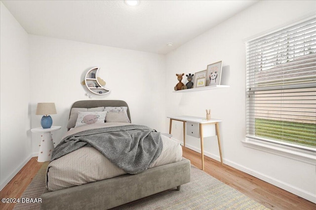 bedroom with hardwood / wood-style floors and multiple windows