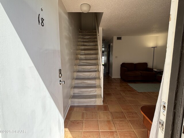 5500 Ocean Shore Blvd Unit 18, Ormond Beach, FL 32176 - staircase with tile patterned floors, visible vents, and a textured ceiling
