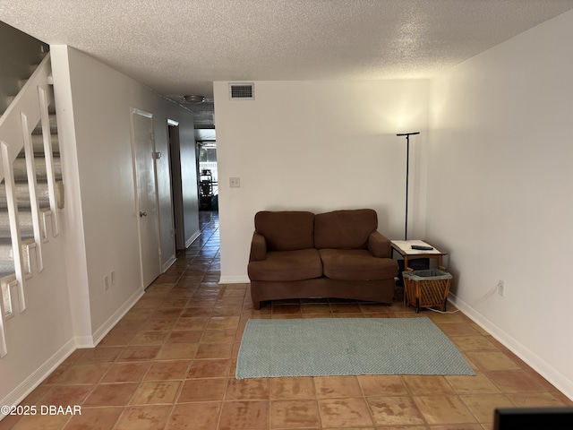 5500 Ocean Shore Blvd Unit 18, Ormond Beach, FL 32176 - tiled living room featuring visible vents, baseboards, stairway, and a textured ceiling