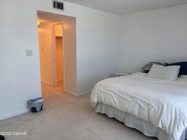 5500 Ocean Shore Blvd Unit 18, Ormond Beach, FL 32176 - bedroom featuring visible vents, baseboards, light carpet, and a textured ceiling