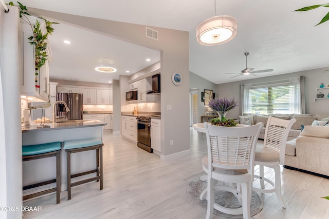 64 Alberta Ave, Ponce Inlet, FL 32127 - dining space with ceiling fan, vaulted ceiling, light wood finished floors, and recessed lighting