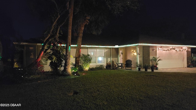 64 Alberta Ave, Ponce Inlet, FL 32127 - view of front of property featuring a garage, a yard, concrete driveway, and brick siding