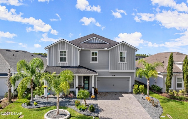 137 Azure Mist Way, Daytona Beach, FL 32124 - view of front of house with board and batten siding, an attached garage, decorative driveway, and a shingled roof