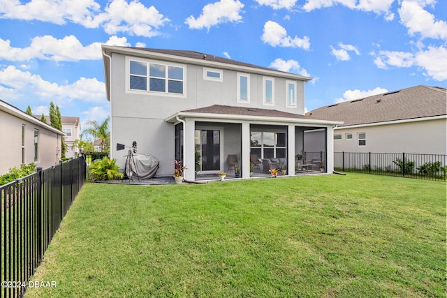 rear view of property with a lawn and a sunroom