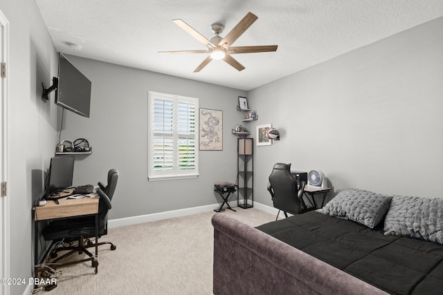 home office featuring a textured ceiling, light colored carpet, and ceiling fan