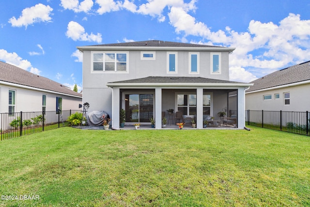 rear view of property featuring a patio area, a sunroom, and a yard