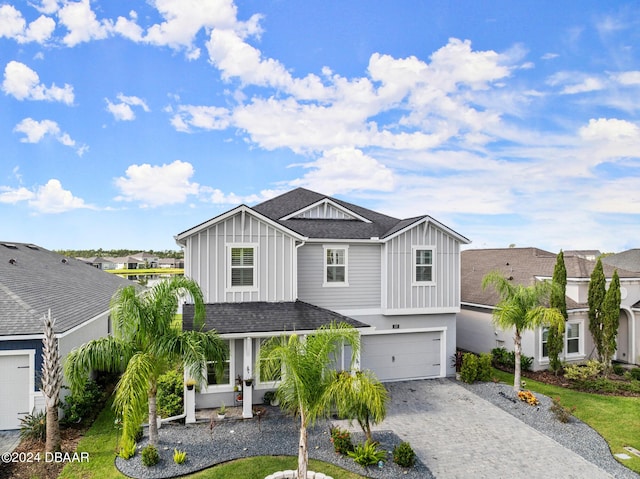 137 Azure Mist Way, Daytona Beach, FL 32124 - view of front of home with board and batten siding, an attached garage, roof with shingles, and decorative driveway