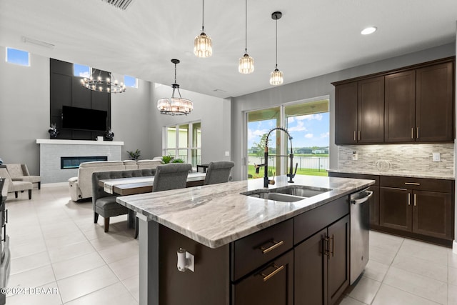 137 Azure Mist Way, Daytona Beach, FL 32124 - kitchen with open floor plan, light tile patterned flooring, dark brown cabinetry, light stone counters, and a fireplace