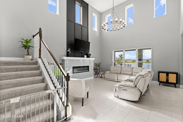 137 Azure Mist Way, Daytona Beach, FL 32124 - living room featuring a towering ceiling, a chandelier, a glass covered fireplace, stairs, and light tile patterned floors