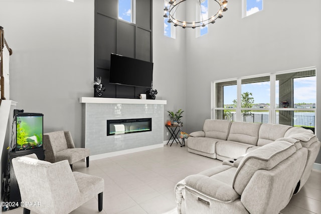 living room featuring a chandelier, a wealth of natural light, and a towering ceiling