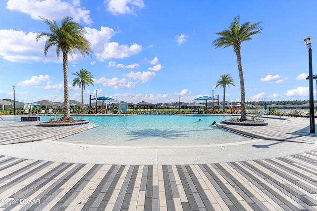 view of swimming pool featuring a patio area and a water view