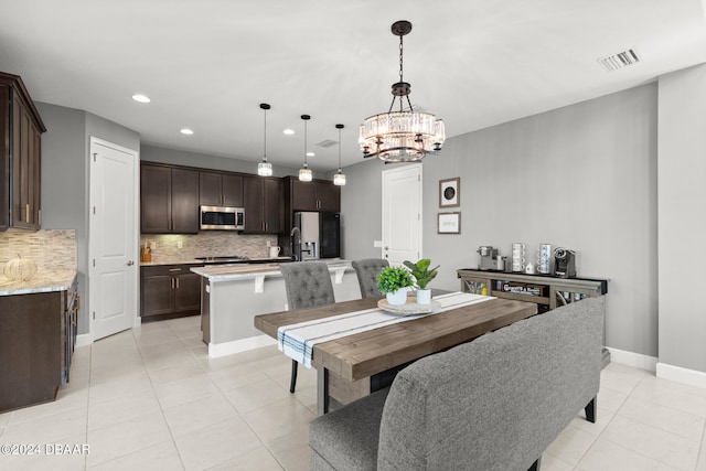 dining area featuring a notable chandelier and light tile patterned flooring