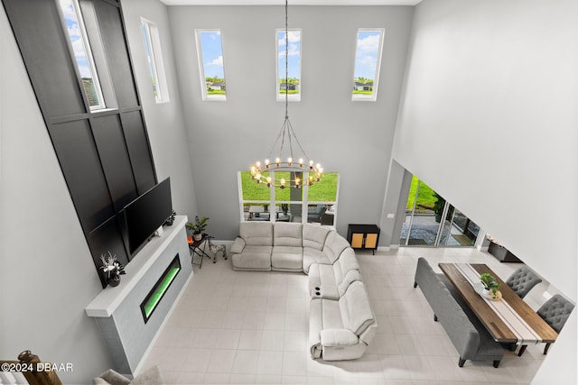 137 Azure Mist Way, Daytona Beach, FL 32124 - living room with a glass covered fireplace, a chandelier, a high ceiling, and tile patterned flooring