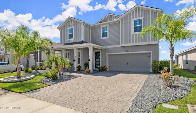 137 Azure Mist Way, Daytona Beach, FL 32124 - view of front of home featuring board and batten siding, decorative driveway, a garage, and stucco siding