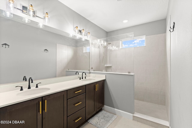 bathroom featuring vanity, tile patterned floors, and a tile shower