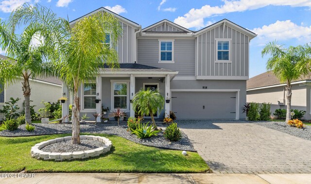 137 Azure Mist Way, Daytona Beach, FL 32124 - view of front of home with decorative driveway, an attached garage, board and batten siding, and stucco siding
