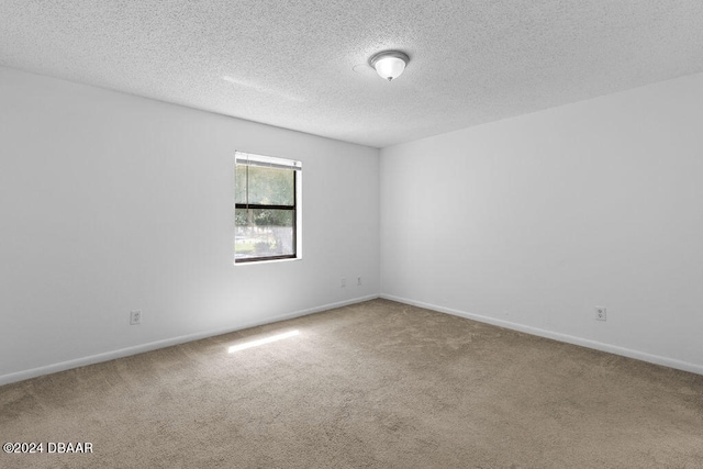 empty room with a textured ceiling and carpet floors