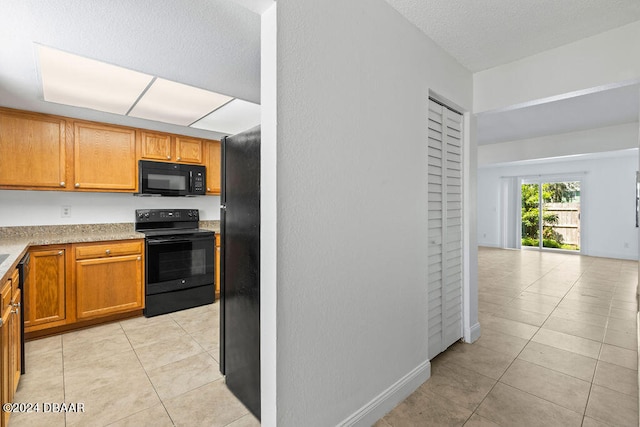 kitchen featuring black appliances and light tile patterned floors