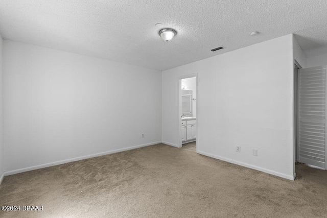 carpeted empty room with a textured ceiling