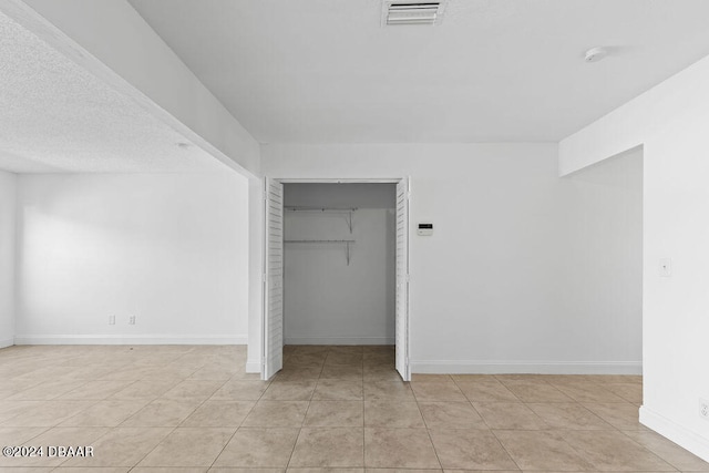 unfurnished bedroom with light tile patterned floors and a closet