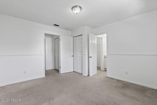 unfurnished bedroom featuring light colored carpet and a textured ceiling