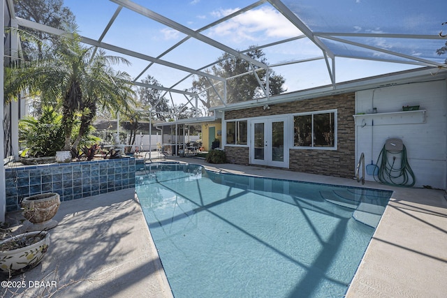 view of swimming pool with a patio, a lanai, and french doors