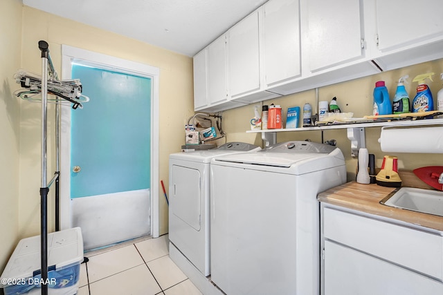 laundry area featuring cabinets, sink, light tile patterned floors, and independent washer and dryer