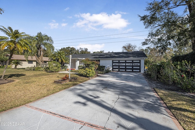 single story home with a garage and a front lawn