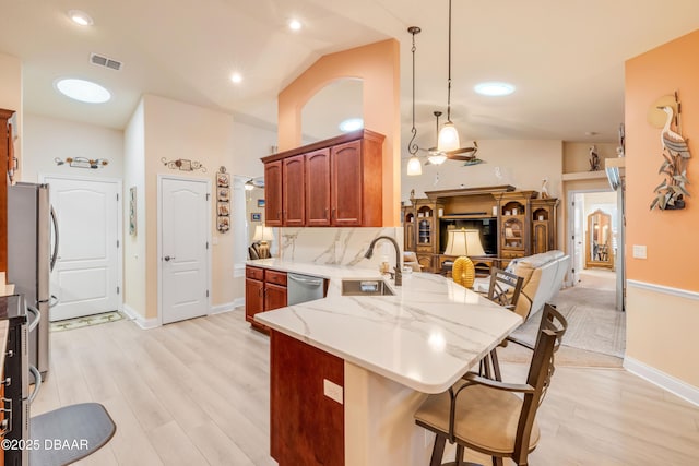 406 Phillips Creek Ln, New Smyrna Beach, FL 32168 - kitchen with a peninsula, appliances with stainless steel finishes, open floor plan, vaulted ceiling, and light wood finished floors
