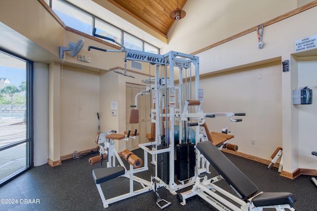 exercise room featuring high vaulted ceiling and wooden ceiling