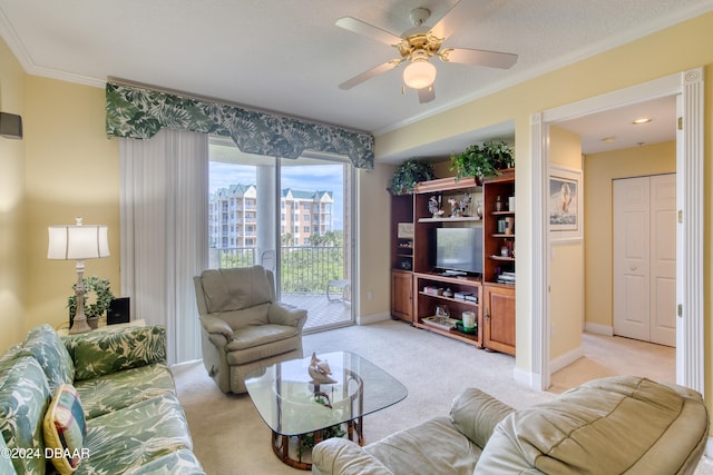 living room with a textured ceiling, light colored carpet, ceiling fan, and crown molding