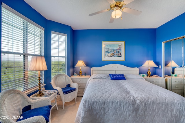 bedroom featuring carpet flooring, ceiling fan, and a textured ceiling