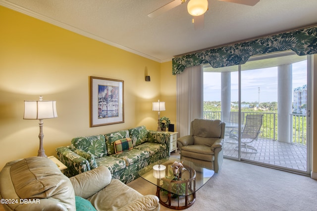 carpeted living room with ceiling fan, a healthy amount of sunlight, a textured ceiling, and ornamental molding