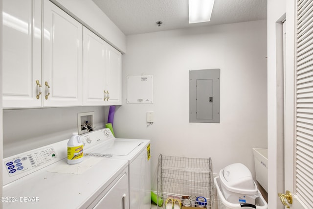 clothes washing area featuring cabinets, washing machine and dryer, a textured ceiling, and electric panel