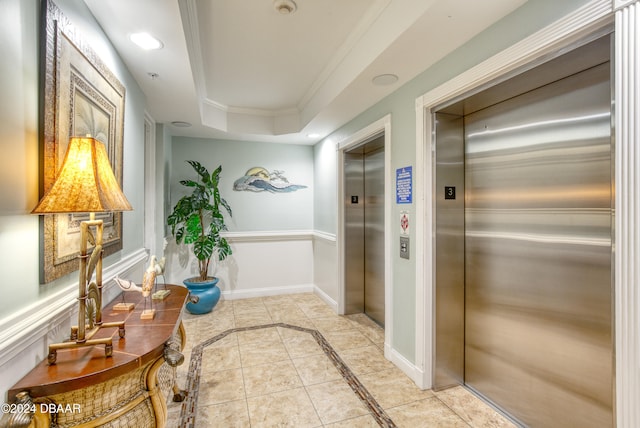 hall featuring light tile patterned floors, elevator, a tray ceiling, and crown molding