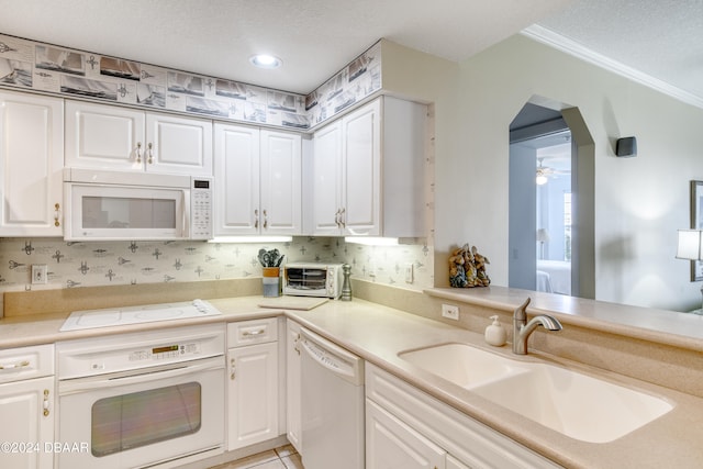 kitchen with ornamental molding, white appliances, sink, light tile patterned floors, and white cabinets