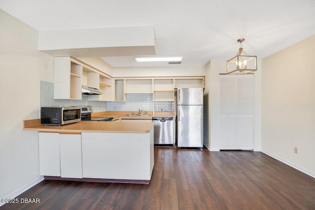 kitchen with under cabinet range hood, stainless steel appliances, a peninsula, a sink, and open shelves