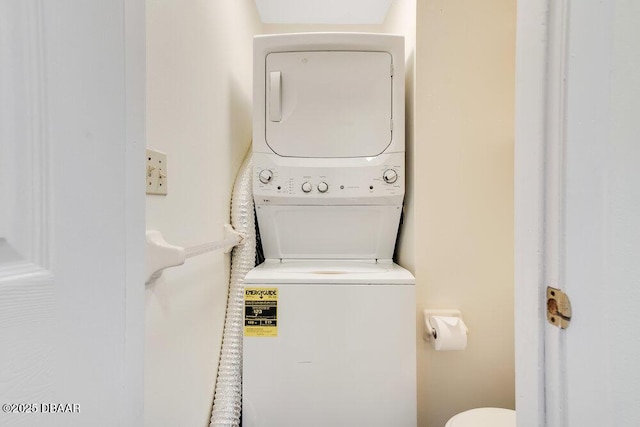 washroom featuring stacked washer / dryer and laundry area