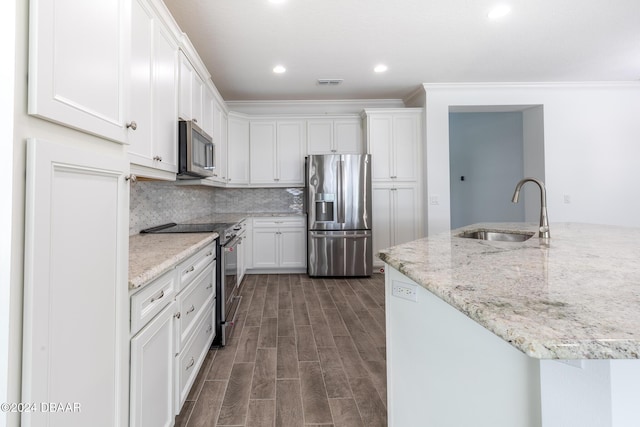544 Good Life Way, Daytona Beach, FL 32124 - kitchen featuring appliances with stainless steel finishes, a sink, white cabinetry, ornamental molding, and recessed lighting