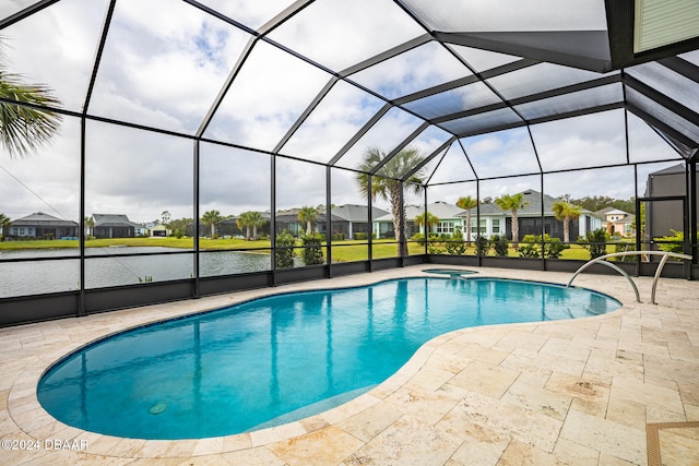 view of pool with a lanai, a water view, a patio, and an in ground hot tub