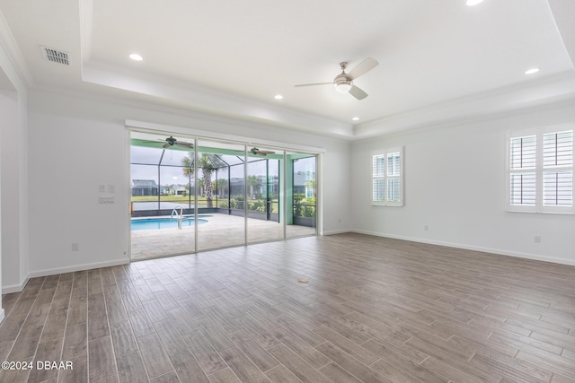 544 Good Life Way, Daytona Beach, FL 32124 - spare room with a tray ceiling, a ceiling fan, crown molding, plenty of natural light, and wood finished floors