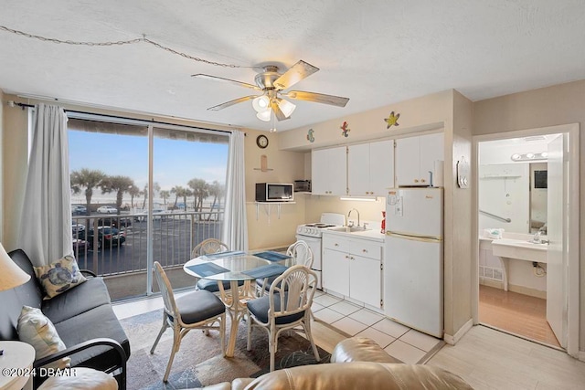 dining space featuring light wood-type flooring, sink, and ceiling fan