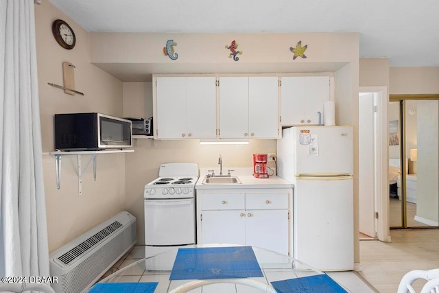 kitchen featuring a wall mounted AC, sink, white cabinets, white appliances, and light hardwood / wood-style flooring