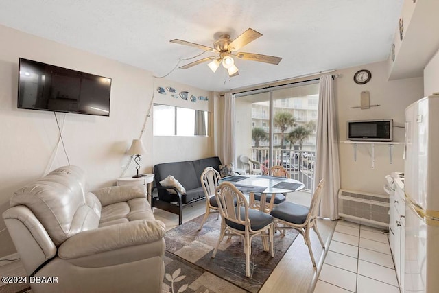 tiled dining room with a wall mounted air conditioner and ceiling fan