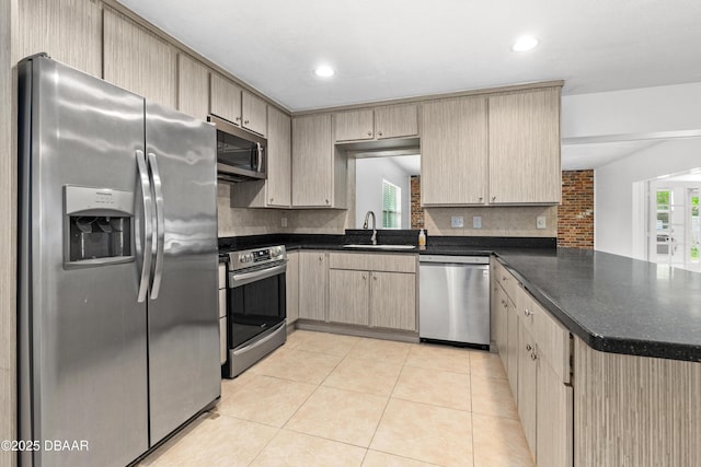 kitchen featuring sink, stainless steel appliances, backsplash, and light brown cabinets