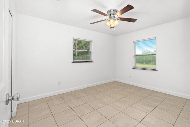 tiled spare room with ceiling fan