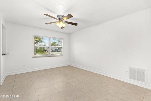 tiled empty room featuring ceiling fan