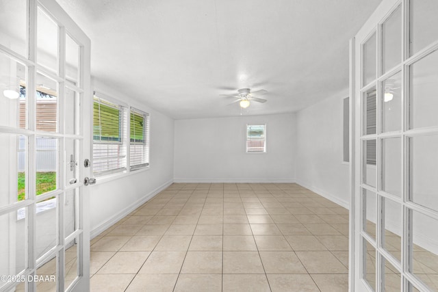 empty room featuring ceiling fan, light tile patterned floors, and french doors