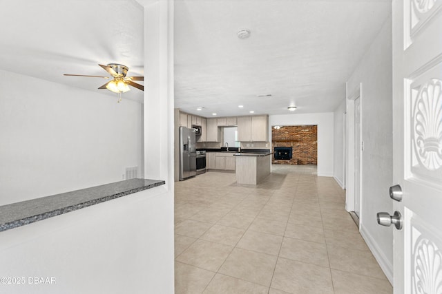 kitchen featuring stainless steel appliances, ceiling fan, kitchen peninsula, and light tile patterned floors