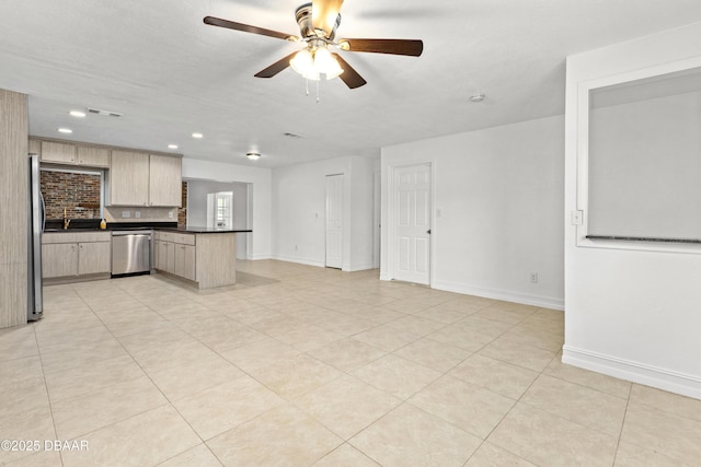 kitchen with ceiling fan, light brown cabinetry, appliances with stainless steel finishes, kitchen peninsula, and backsplash